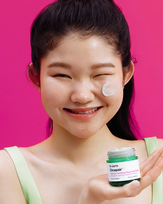 Woman smooths CIcapair Cooling Gel Cream onto her cheeks.